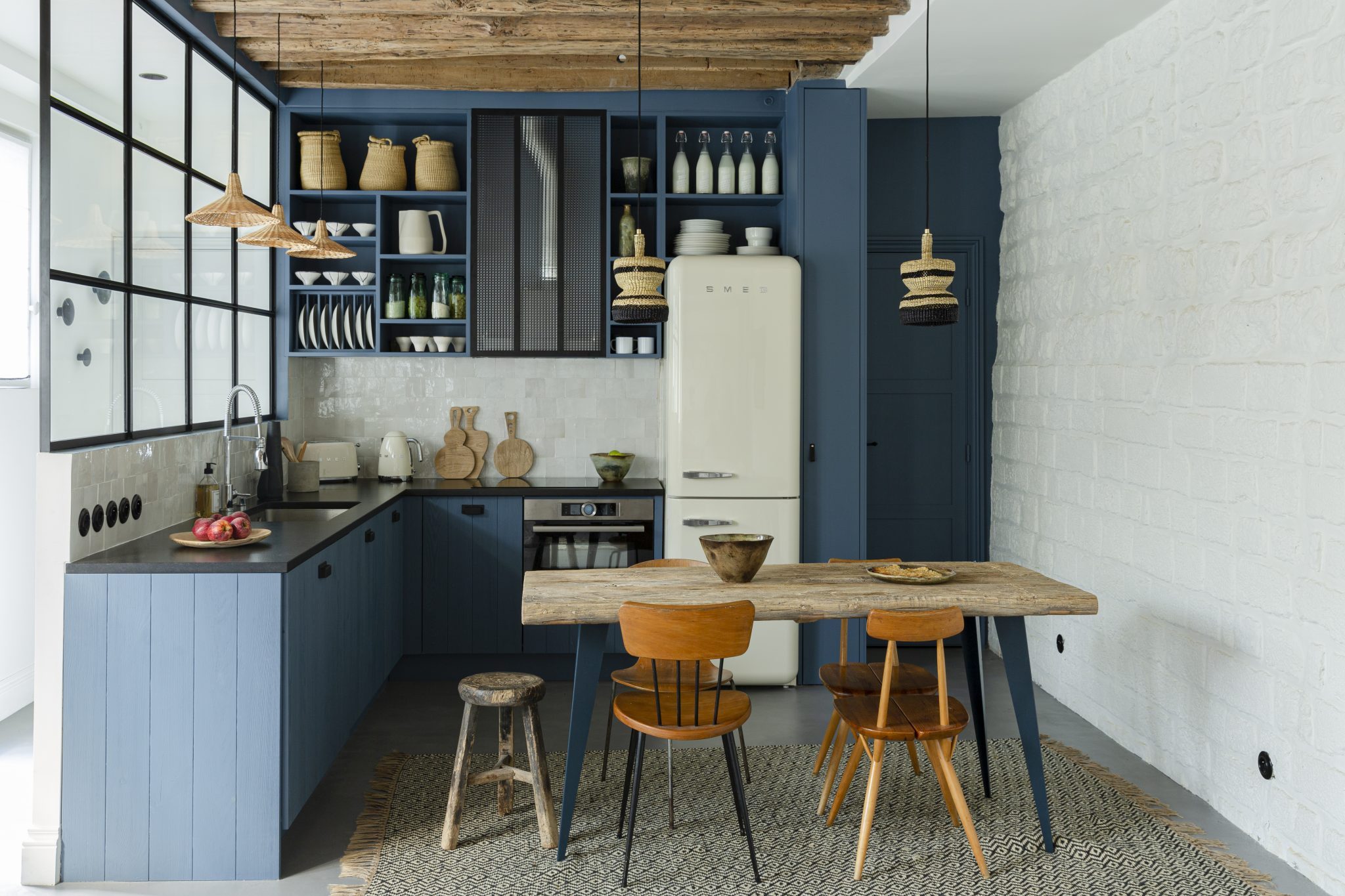 the small apartment kitchen is anchored with waxed concrete floors, blue painte 9