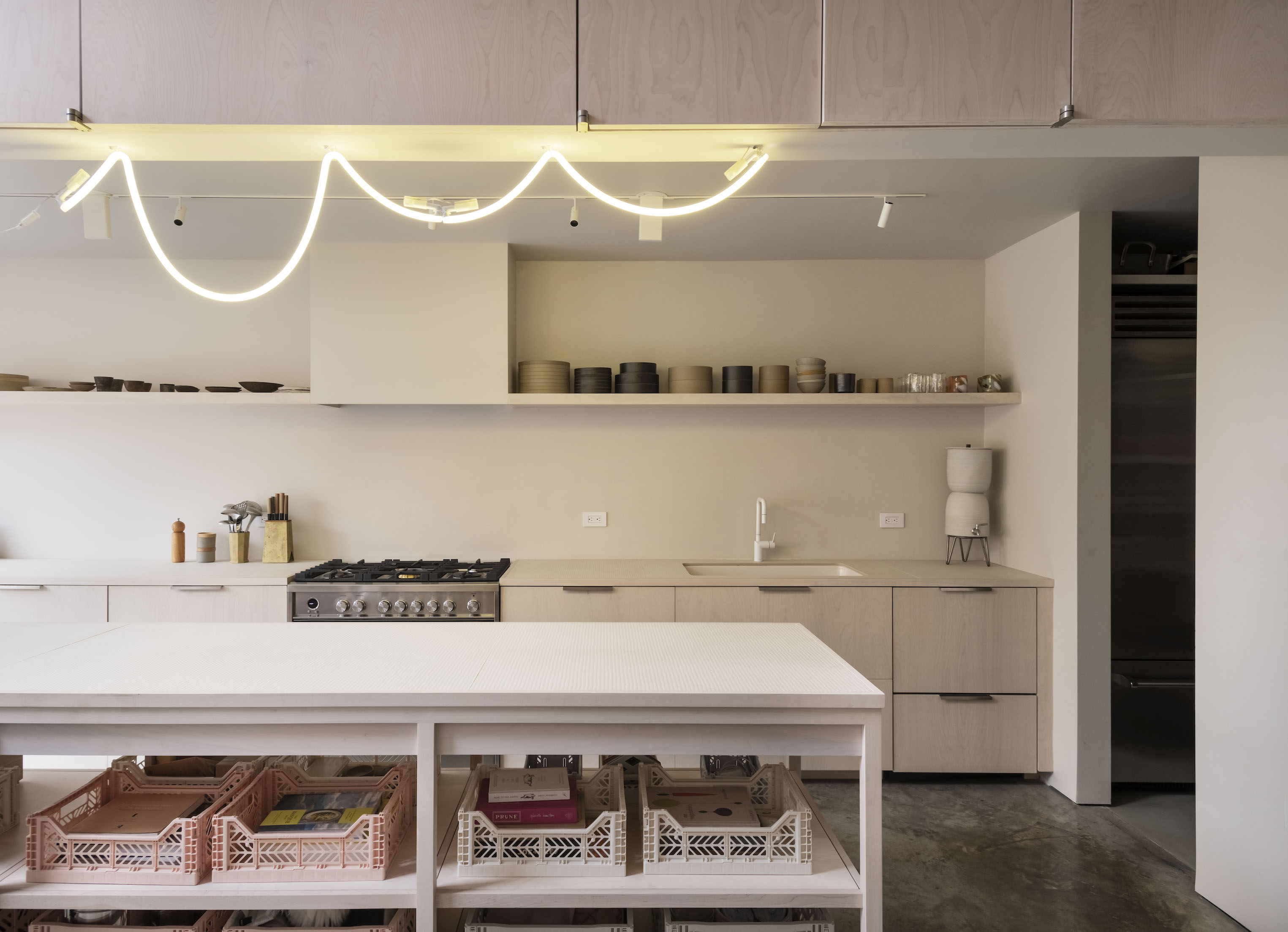 the kitchen is anchored with polished concrete floors, a wall of paneled storag 9