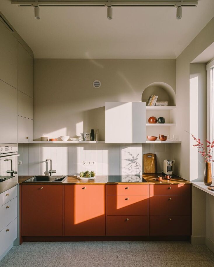 the petite kitchen pairs pale grey and beige with rust red, a nod to the color  9