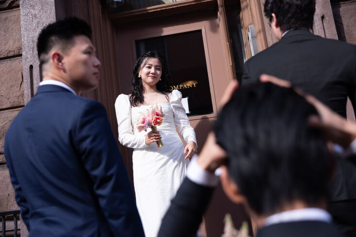 the bride greets the groom carrying a bouquet she made herself. her dress is fr 10