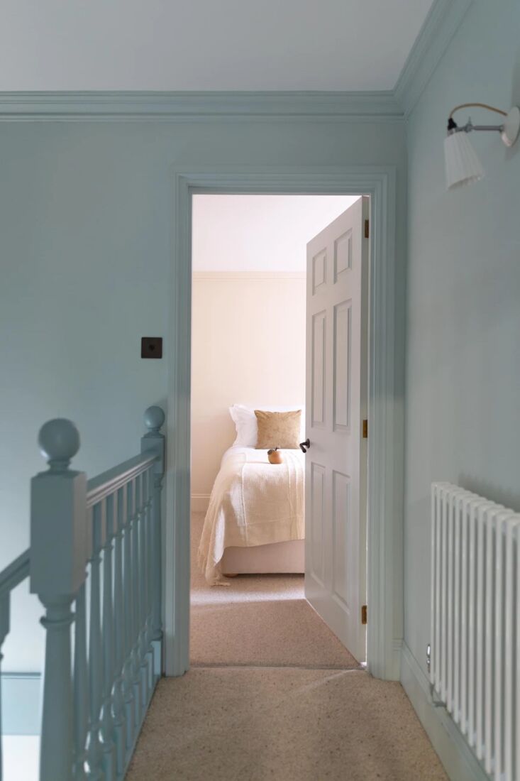 upstairs, a blue hued hall leads into one of two bedrooms. 17