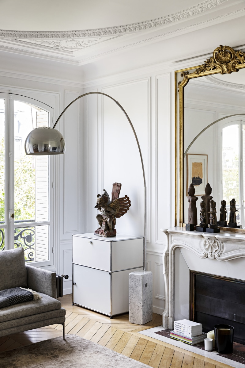 a small modern storage cabinet offsets the antique mirror and statuary. photogr 10