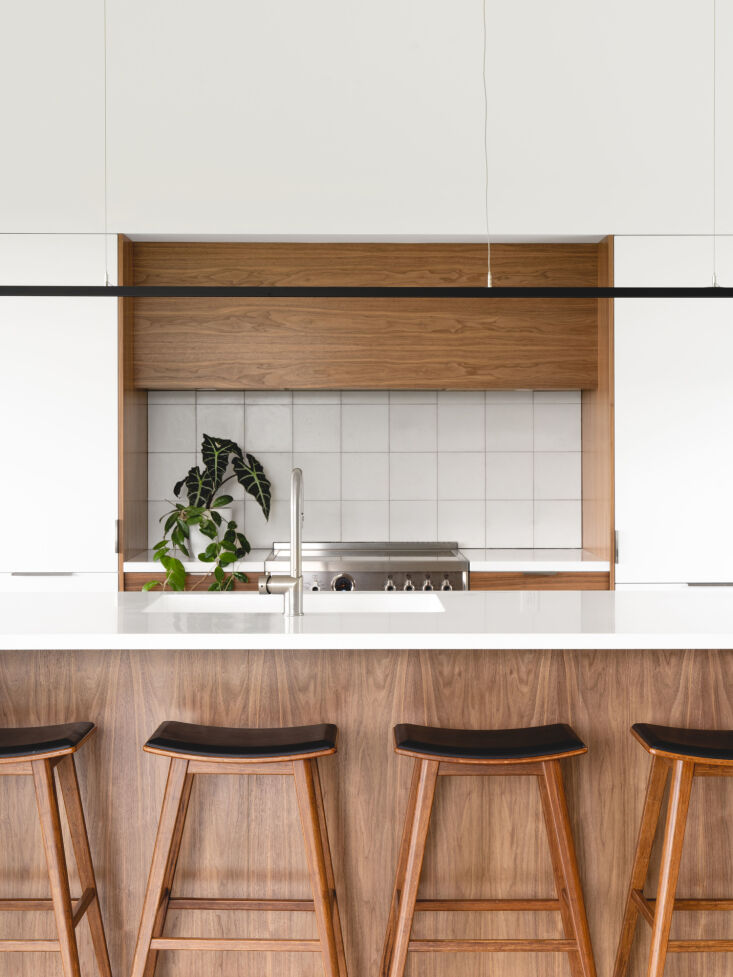 the kitchen has streamlined components, including black walnut detailing and a  13