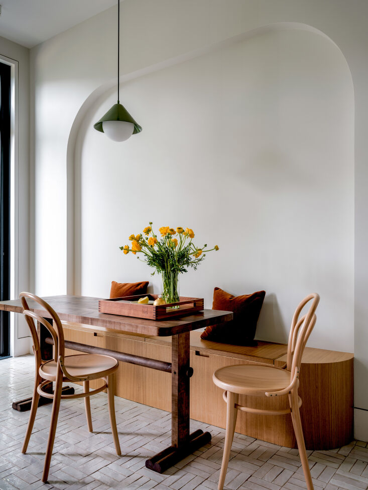 the breakfast nook is set in a niche that echoes an archway at the entrance. th 13