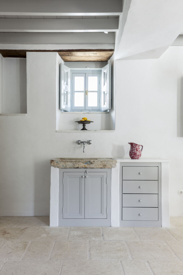 the stone kitchen sink is paired with a wall mounted faucet. the spatterware ju 15