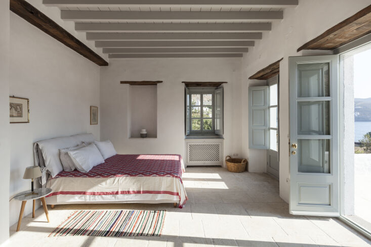 the bedroom gets its color from antique rugs and a locally woven textile as a b 18