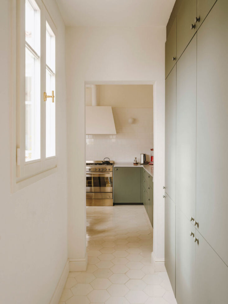in the hallway, a wall of cabinets conceals the refrigerator and ample storage. 13