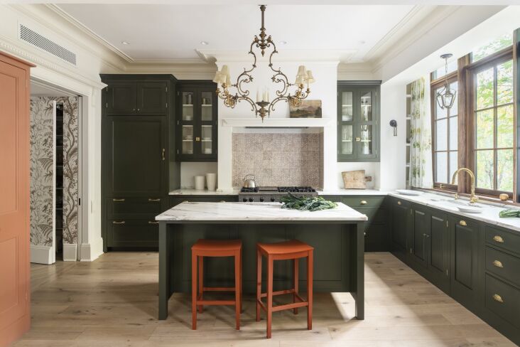 a view of the dynamic kitchen showcases standout red stools, brass hardware, an 14