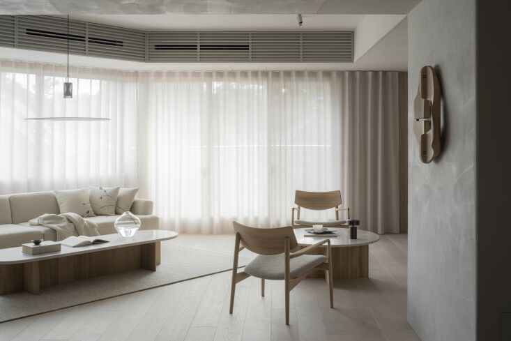 in contrast, the living area is flooded with natural light. ethereal curtains l 10
