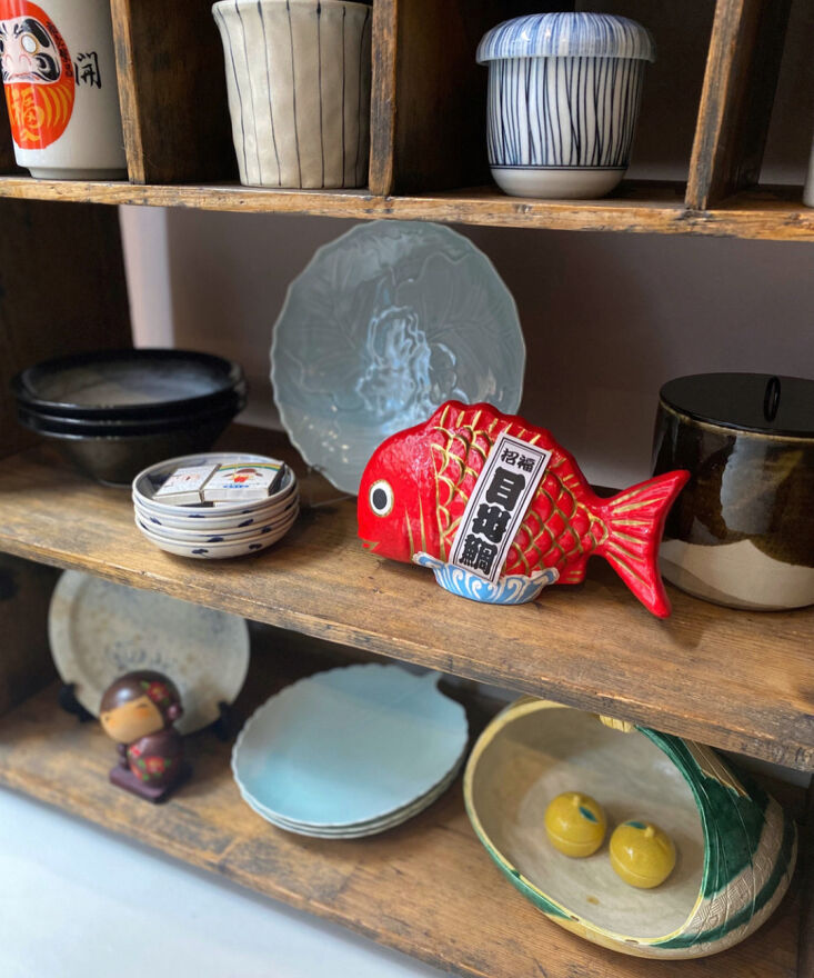 a red tai fish and ceramics on an antique wood display. 17