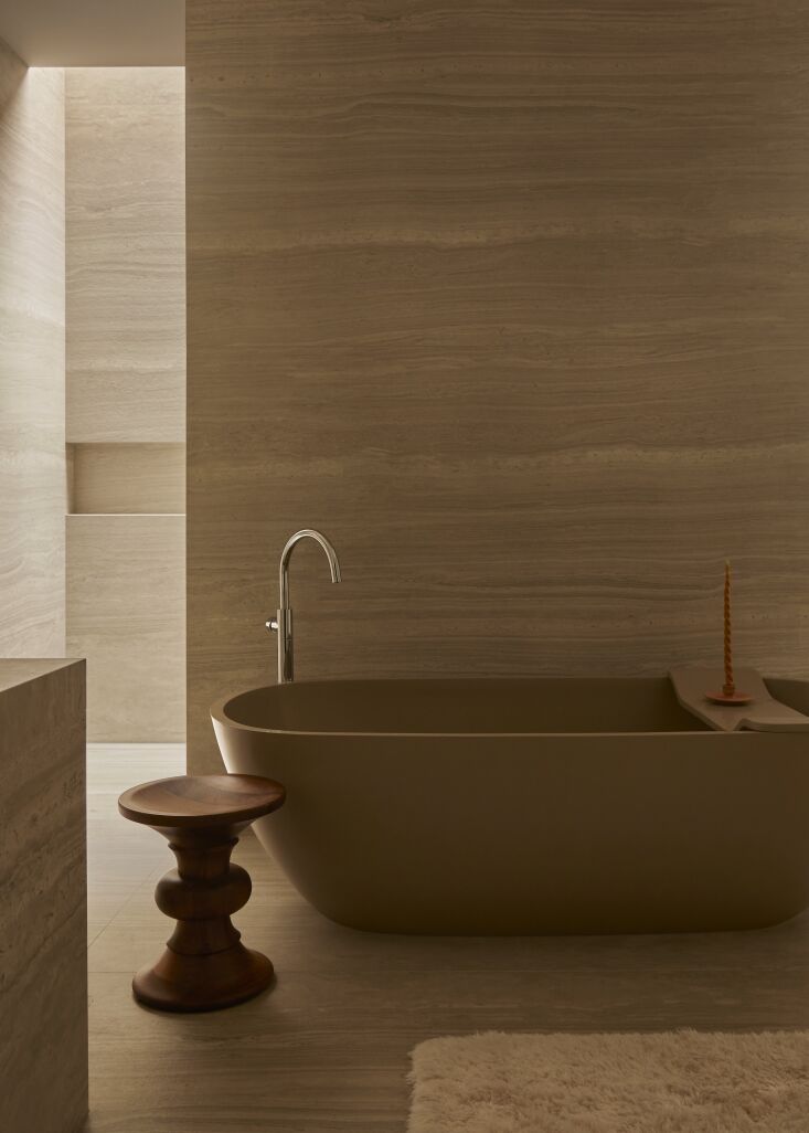 the main bath is finished in a travertine lookalike: neolith’s strata ar 19
