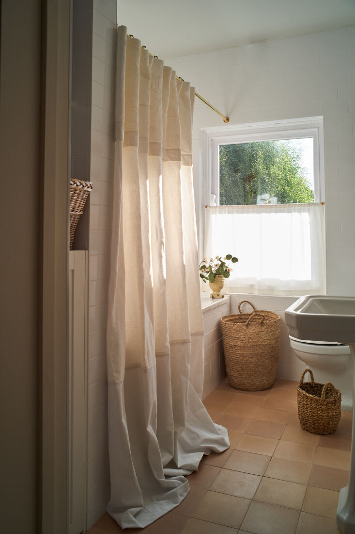 the previous bathroom was sleek and modern. sophie softened it with terracotta  15