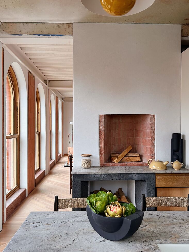 a wood burning brick fireplace with firewood storage below. the bowl is by farr 14