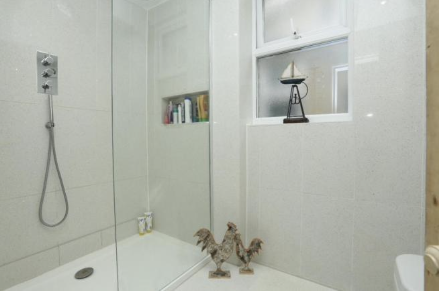 the shower room was previously covered in the same outsized white tile as the b 18