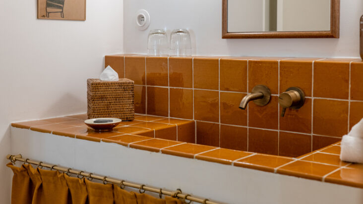 glazed tiles in quintessential provençal yellow cover the bathroom vanitie 14