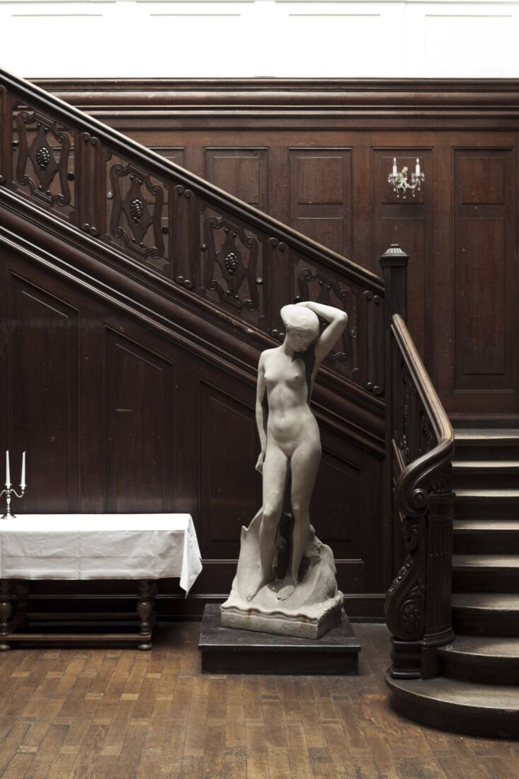 a classical statue anchors the stairwell. 18