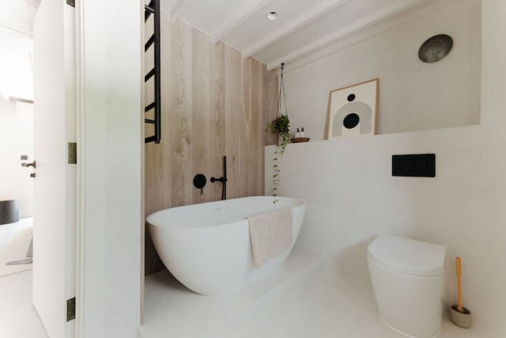 a deep tub in the simple ground floor bathroom. the print is by the australian  25