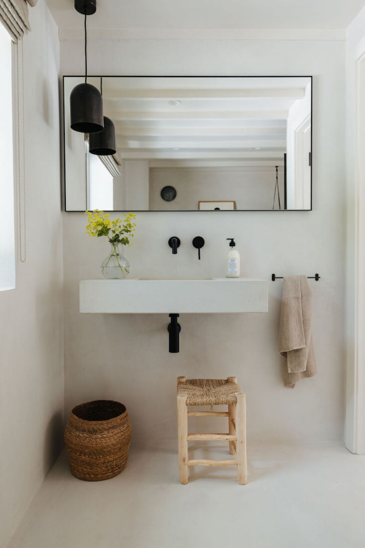 the simple micro cemented bathroom is softened with natural accessories. 26