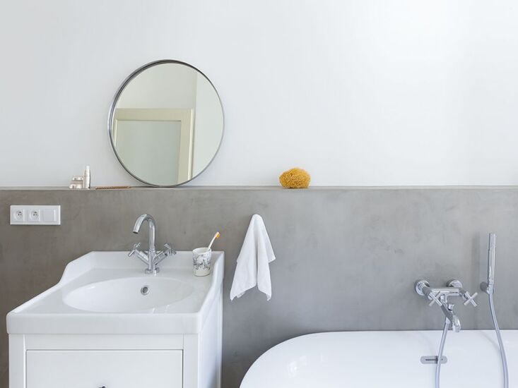 a round mirror is mounted to look as though leaning from the lip of the concret 16