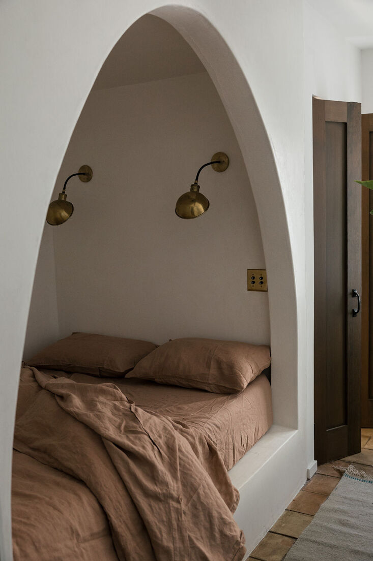 in the guest room, sarah carved out an arched sleeping nook to maximize square  22