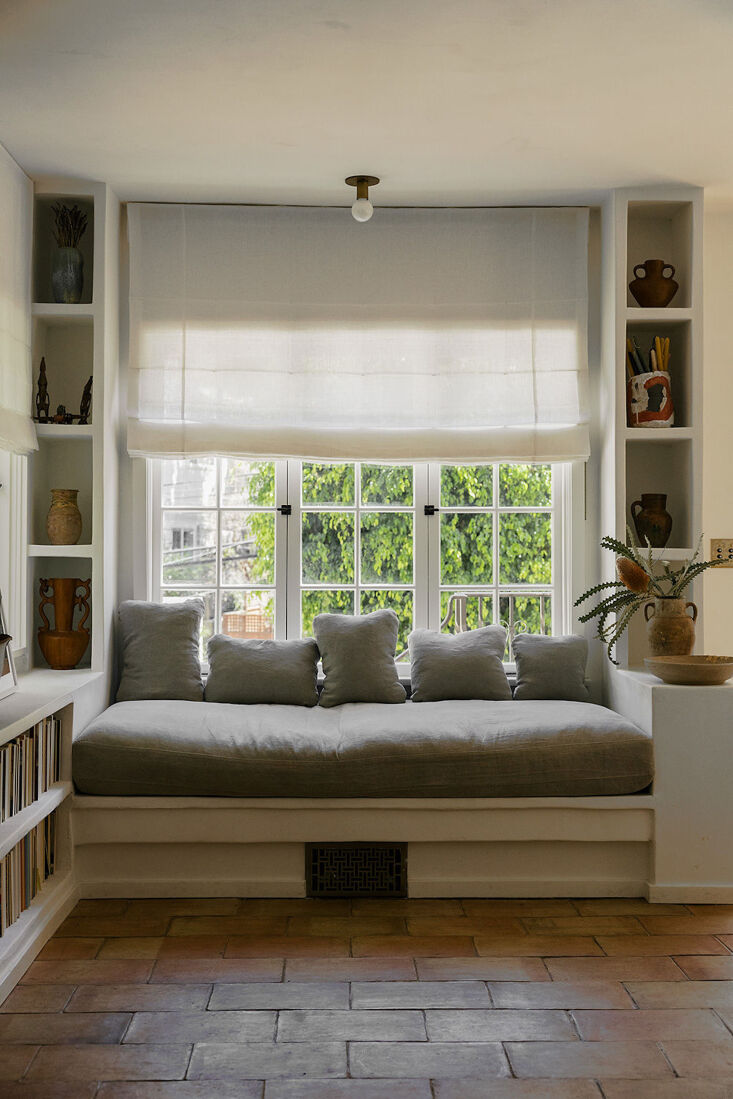 a built in bench is nestled between bookshelves, in case the homeowners want to 16