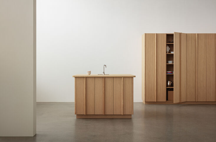 the column kitchen—and island—in natural oak. the handles bisect  20