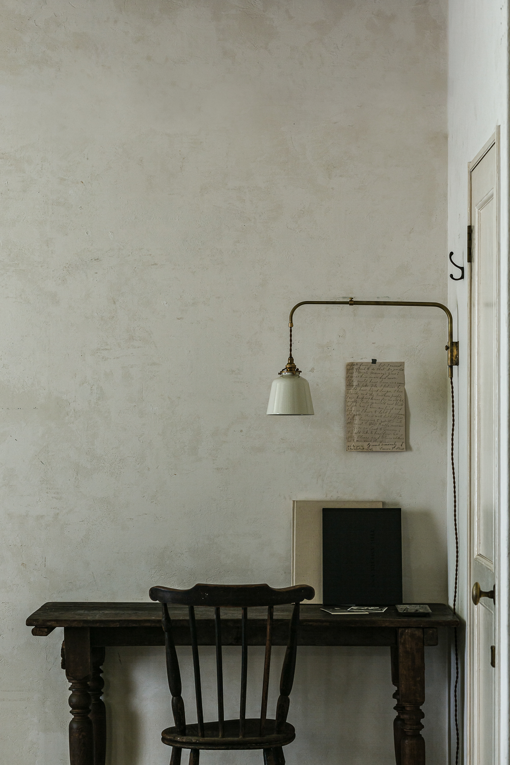 a brass hanger mini light with a movable arm and baba enamel shade. 20