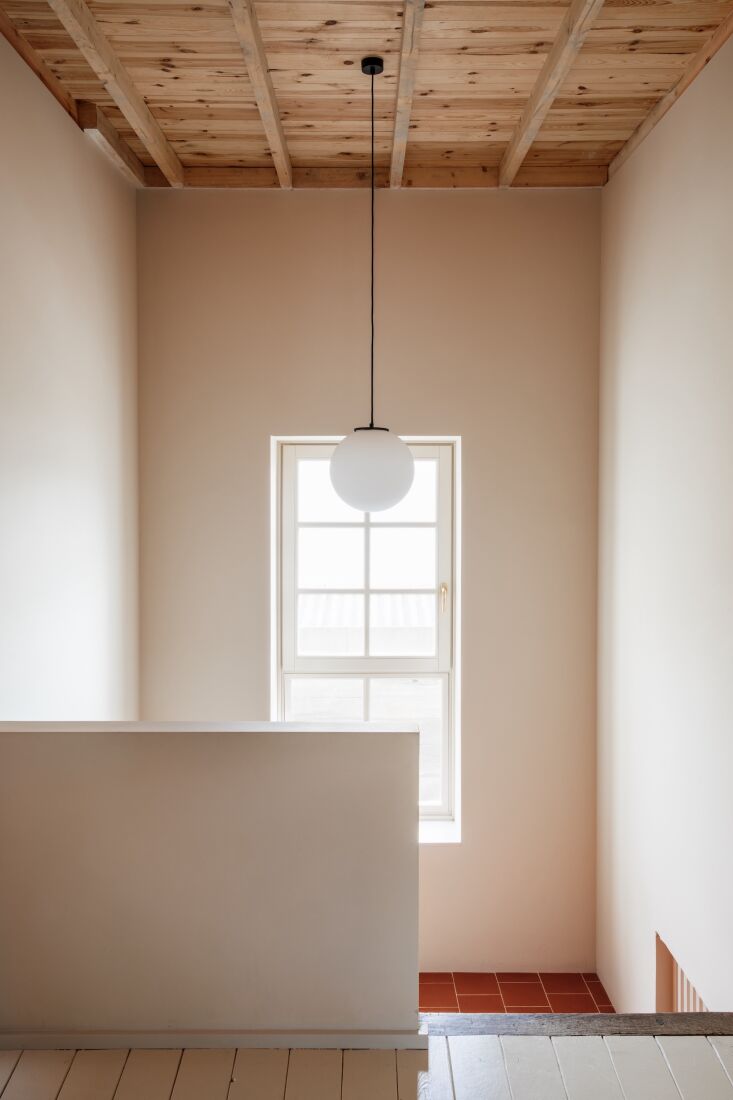 terracotta tiles transition to painted pine floors on the second level. the cei 18