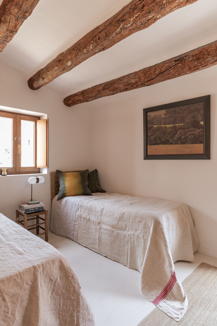 original beams and raw linen coverlets in a twin bedroom. 27