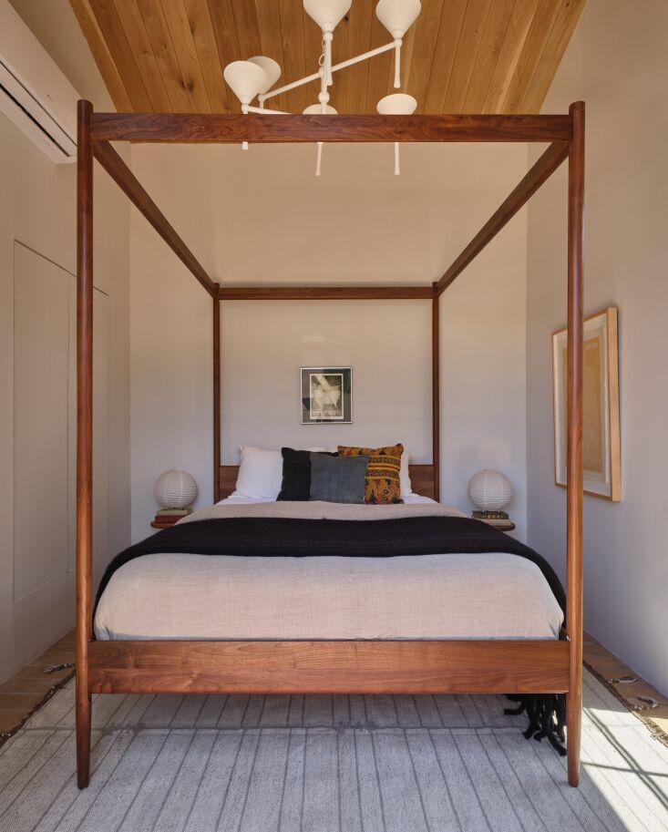the small bedroom overlooks the pool. the cove canopy bed was sourced from dwr, 19