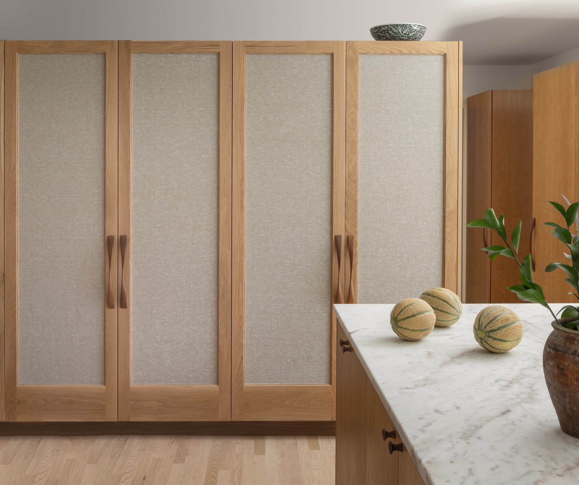 the dining room cabinets are inset with a textured fabric as a way to distingui 20