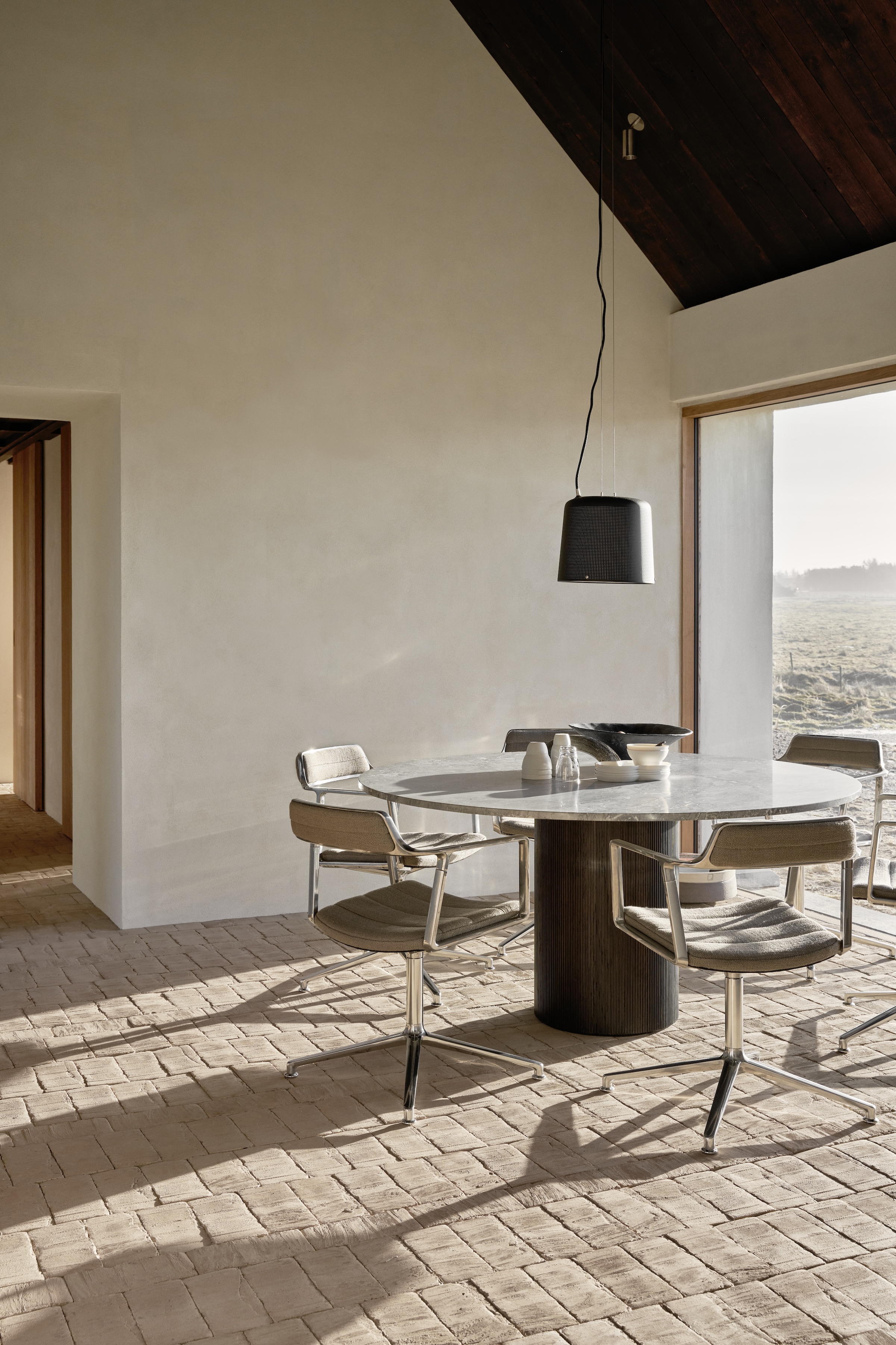 a limestone topped vipp cabin round table is surrounded by vipp swivel chairs i 24