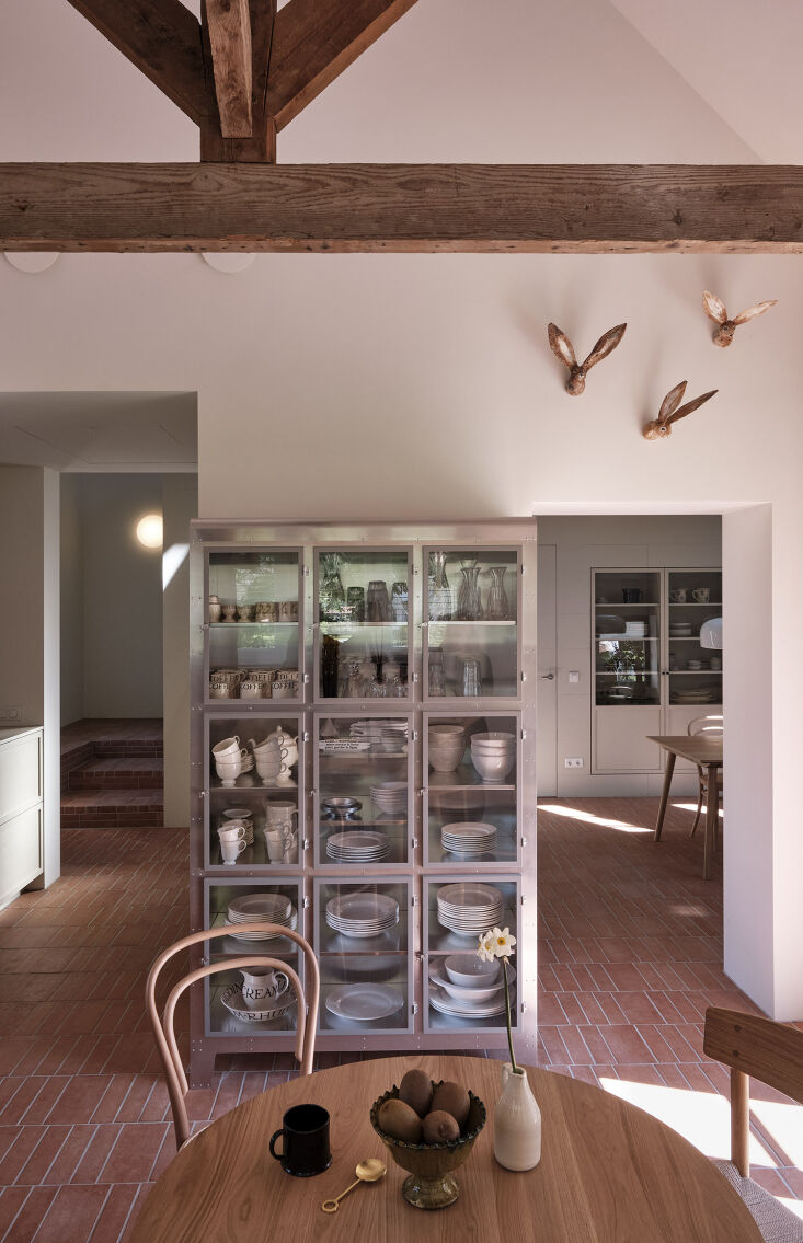 a freestanding china cabinet in the kitchen; beyond is a built in china in the  29