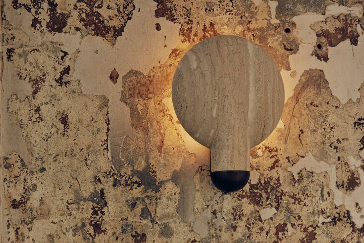 studio henry wilson makes the blackened classico travertine surface wall sconce 25