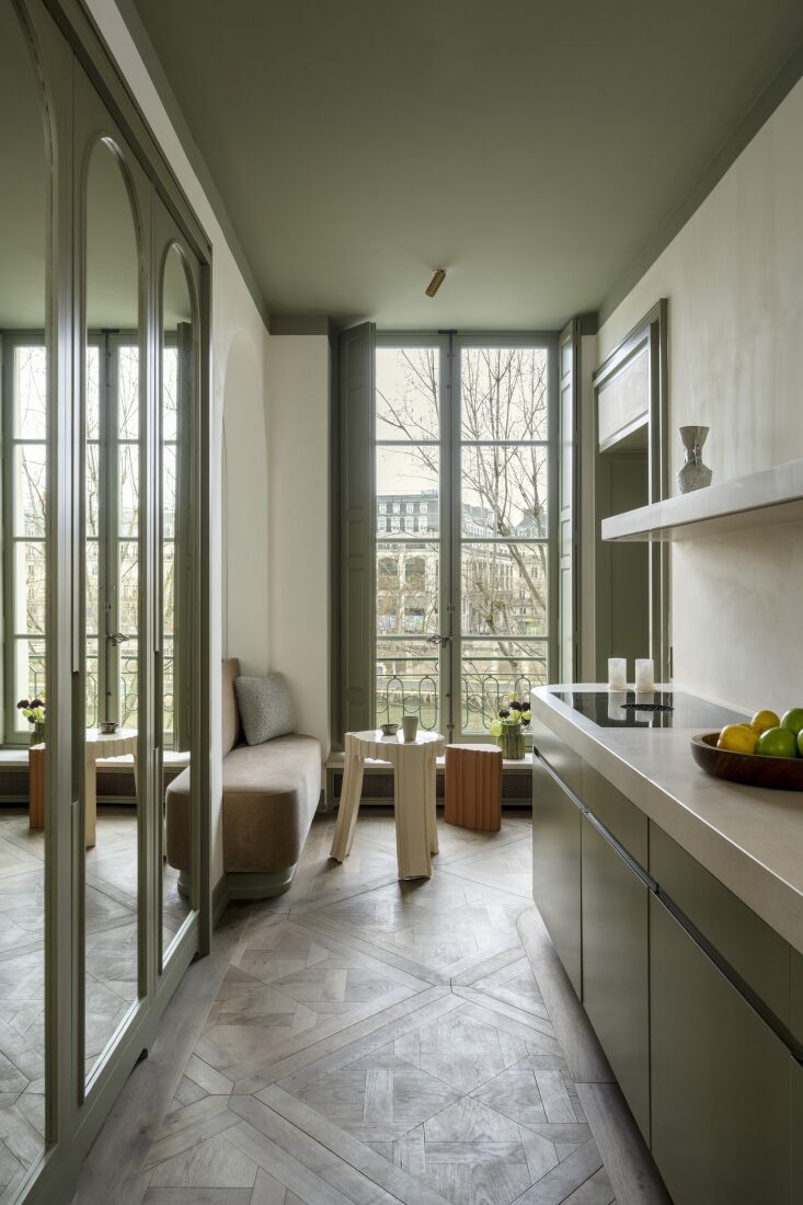 La cocina está diseñada con gabinetes de madera personalizados pintados de verde23