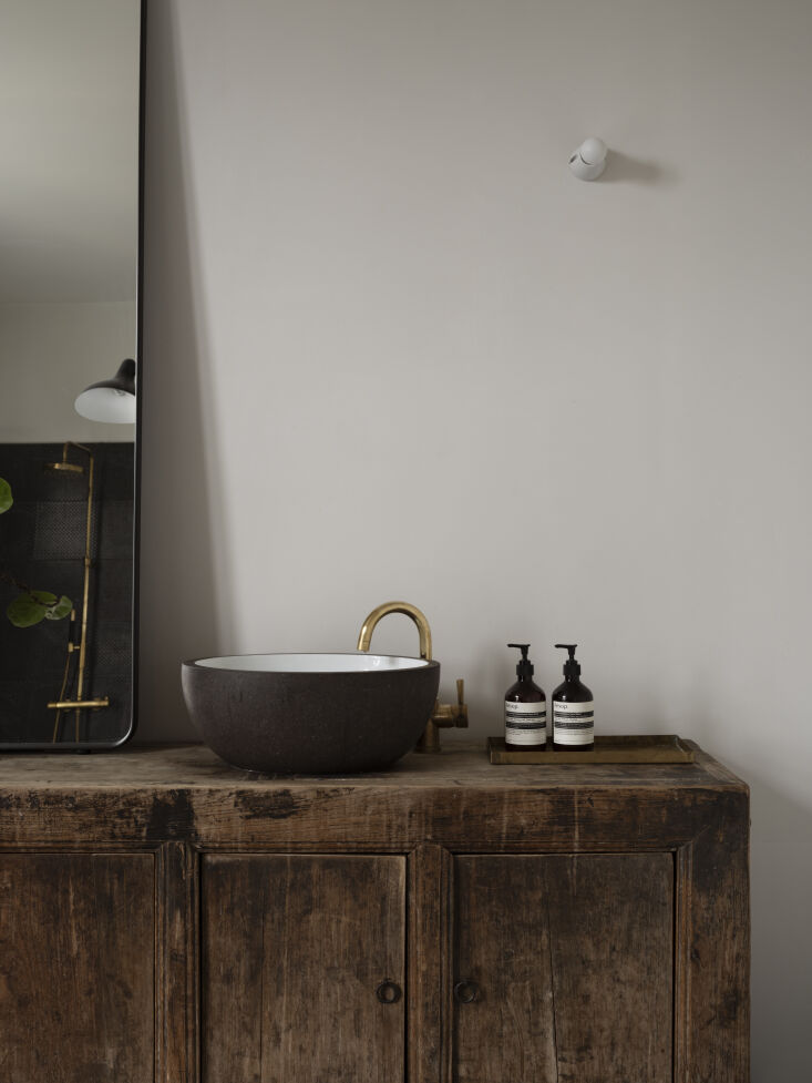 the made a mano glazed lava stone basin paired with a single hand raw brass fau 29