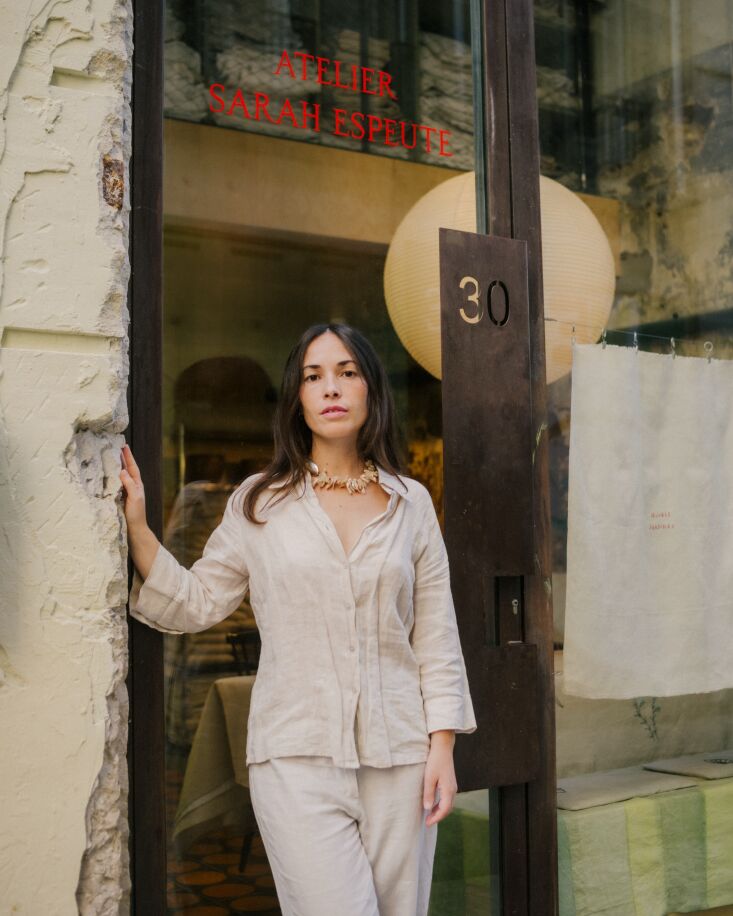 sarah stands in the doorway beneath a hand painted storefront by ln graph in ma 34