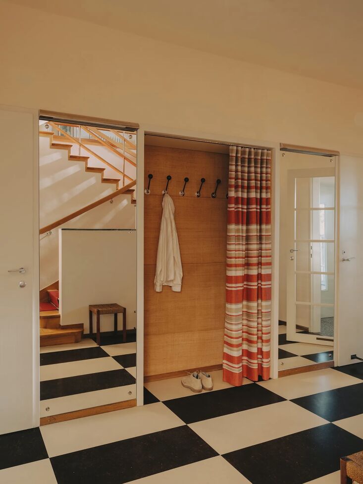 a curtained storage entryway and rectangular black and white floor tiles. 20