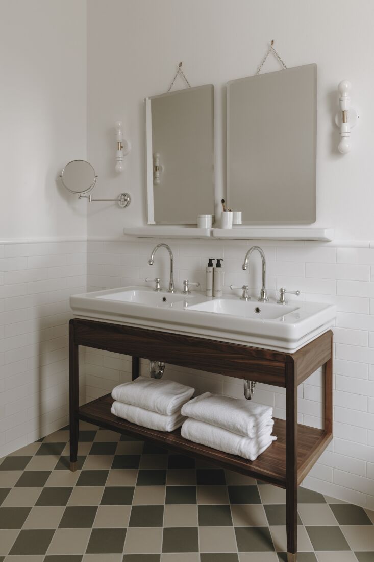 bathrooms are designed with white tiles, frameless mirrors, and traditional fix 34