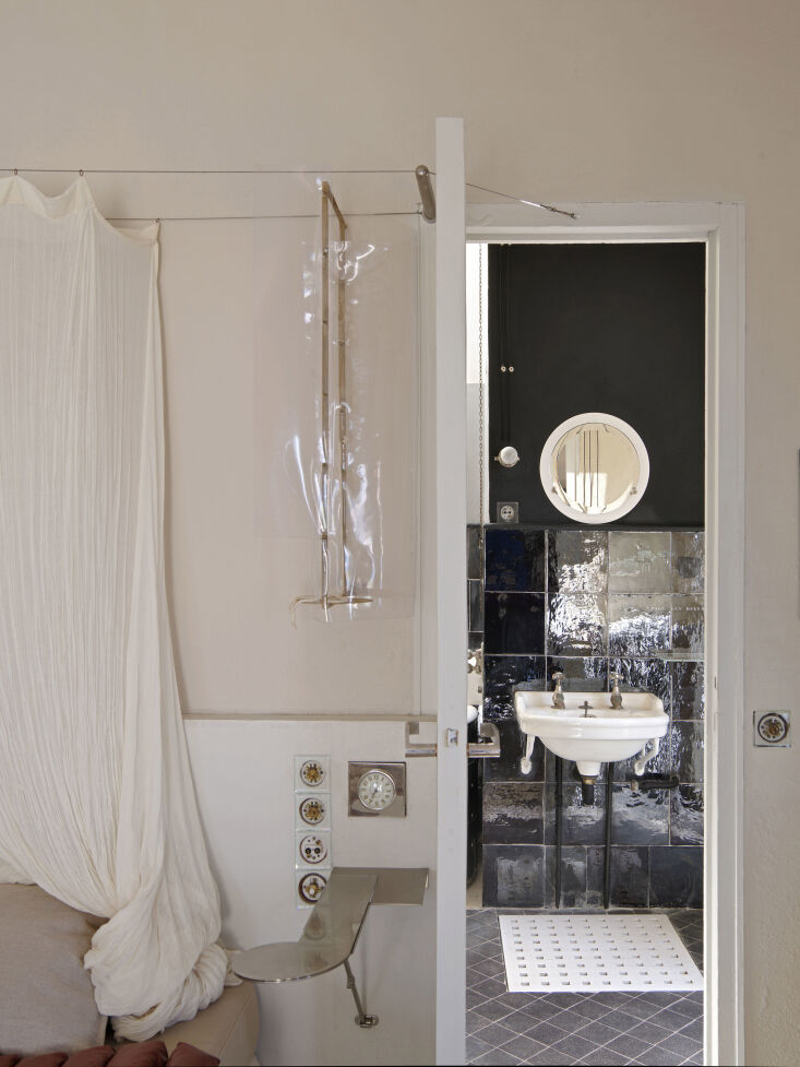 glossy black tiles and black painted walls distinguish the primary bathroom fro 27