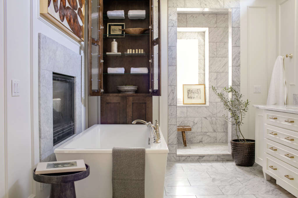 relaxing, free standing soaking tub cozied next to a gas fireplace 8