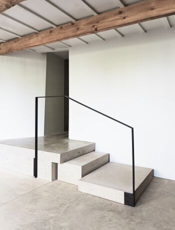 lower mill concrete flooring and staircase with custom metal black hand rail by mclaren excell